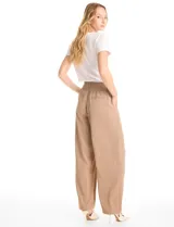 Pantalón tipo palazzo de corte ancho y fluido, confeccionado en tejido sastrero. Presenta tiro alto con doble abotonadura frontal, pinzas decorativas y cintura elástica en la parte posterior. Incluye bolsillos laterales funcionales.