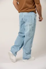 Jean baggy para hombre, color celeste claro, de corte holgado estilo cargo con bolsillos laterales y refuerzos en las rodillas.