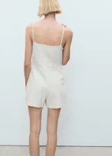 Vestido corto de algodón estilo denim con diseño sin mangas, tirantes finos, cuello escotado y cierre de cremallera lateral.