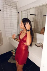 Vestido corto negro con escote en V, breteles finos cruzados en la espalda y cut-outs laterales bajo el busto.