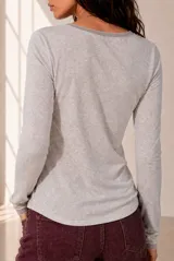 Remera de manga larga y escote en V, color celeste melange, de calce cómodo y relajado.