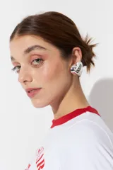 Aros plateados con forma de corazón, con sistema de clip para sujetar a la oreja sin necesidad de perforación.
