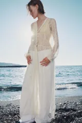 Vestido largo ZW Collection confeccionado en tejido de encaje blanco, con escote en V, manga larga terminada en elástico con volante y cierre frontal de botones forrados.