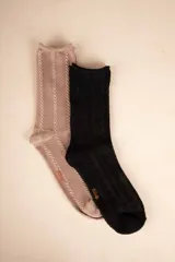 Par de medias de caña media, una color beige con diseño de trenzas verticales y otra negra con diseño de rombos.