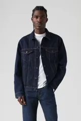 Campera de denim azul oscuro, modelo Trucker clásico con cuello camisero, cierre frontal con botones metálicos, bolsillos con solapa en el pecho y bolsillos laterales.