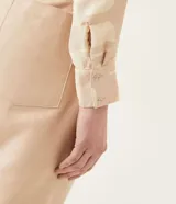 Camisa color beige con estampado geométrico, cuello camisero, manga larga y lazo frontal.