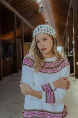 Sweater blanco de algodón con cuello redondo y diseño geométrico en tonos rosa, marrón y blanco en el pecho, puños y ruedo.