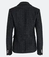 Blazer negro de tweed con hilos metalizados, corte entallado, escote en V profundo, bolsillos delanteros con solapa y doble botonadura con seis botones decorativos de strass.