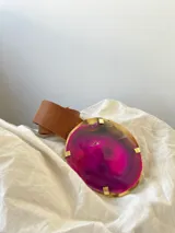 Cinturón de cuero marrón con una hebilla XL de diseño artesanal, compuesta por una piedra de ágata en tonos fucsia y violeta engarzada en una base metálica dorada.