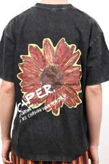 Remera negra de algodón con efecto acid wash, con estampado de girasol en la espalda y la palabra "CAPER." en blanco.