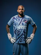 Camiseta de arquero Umbro del Club Nacional de Football para la temporada 2025, en tonos de azul con un patrón gráfico abstracto en el frente. Cuenta con cuello redondo y mangas cortas con detalles en azul oscuro. Incluye el logo de Umbro, el escudo del club y sponsors estampados.