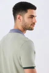 Remera polo de manga corta en color índigo con cuello y botones en contraste. Presenta detalles de color en los puños, aportando un toque sutil y moderno.
