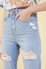Pantalón de jean celeste con roturas en las rodillas, corte mom fit y tiro alto.