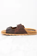 Sandalias de cuero marrón con doble tira ajustable con hebilla metálica.