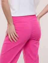 Pantalón capri estilo sastrero de tiro alto y color fucsia, marca Zac & Rachel, confeccionado en tejido elástico con cintura ancha sin cierres ni botones y bolsillos funcionales en el frente.