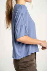 Remera celeste de corte amplio con mangas cortas con volados.