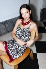 Top blanco con estampado floral negro, corte sencillo, escote abullonado, tiras finas y espalda abierta.