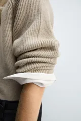 Jersey de punto con diseño boxy fit, cuello redondo y manga larga. Presenta una textura acanalada y acabados en rib en puños y ruedo.