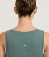 Musculosa deportiva de mujer marca Get Over, confeccionada en tejido de poliamida con elastano. Presenta escote redondo, sisas amplias y un diseño holgado con recorte horizontal en la espalda que incluye un pliegue central para mayor libertad de movimiento.