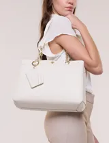 Cartera de hombro de cuero sintético beige, con estructura tripartita de compartimento central con cierre y dos compartimentos laterales con broche magnético. Posee asas dobles con detalles de cadena metálica dorada y un tarjetero independiente desmontable.