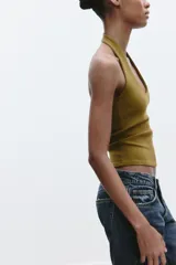 Top de punto con cuello halter y escote redondo profundo, sin mangas y corte ajustado.