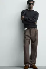 Pantalón straight fit color negro confeccionado en tejido con lana, con detalle de pliegues en el delantero, bolsillos frontales y traseros, y cierre frontal con cremallera y botón.