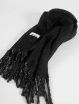 Bufanda de tejido suave color negro con destellos plateados de lurex, terminación con flecos y etiqueta de marca Symphorine.