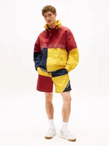 Campera de nailon con diseño color block en rojo, amarillo y azul marino. Tiene cuello alto, cierre de cremallera oculto con botones a presión, puños y bajo elásticos, dos bolsillos ribeteados en la cintura y logo de Tommy Hilfiger en la parte delantera, la trasera y las mangas.