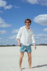 Short de baño celeste con estampado de hojas de palmera en blanco.