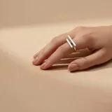 Anillo de plata 925 con diseño de dos barras paralelas que se superponen en el dedo.