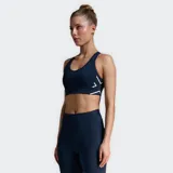 Top deportivo gris con espalda cruzada y logo blanco en el lateral.