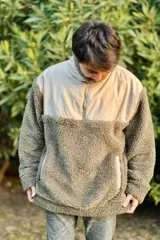 Buzo de cuello alto con cierre a mitad del pecho, color verde con parte superior beige y bolsillo tipo canguro.