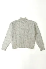 Buzo de punto con diseño de trenzas, cuello alto y textura jaspeada en color beige.
