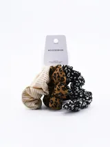 Set de tres scrunchies para el pelo, uno con estampado de manchas en blanco y negro, otro color beige plisado y otro con estampado animal print.