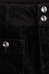 Pollera mini de denim negro con tiro bajo, cierre frontal y dos bolsillos delanteros tipo cargo. Presenta botones decorativos con detalles de strass en la cintura y en las solapas de los bolsillos.