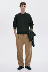 Buzo de punto acanalado color verde oscuro, de manga larga y cuello redondo, con corte regular fit.