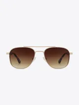 Lentes de sol estilo aviador con armazón dorado y cristales marrones degradados.