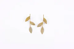 Aros colgantes dorados con forma de hojas.