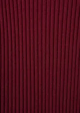 Vestido midi de punto acanalado en color bordó, con cuello perkins y mangas largas acampanadas. Presenta un diseño entallado al cuerpo.