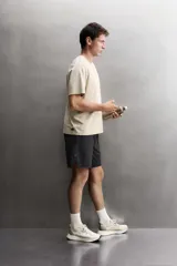 Pantalón corto deportivo de Zara Athleticz confeccionado en tejido técnico ligero y elástico de color negro. Cuenta con cintura elástica ajustable con cordón, bolsillos frontales y aberturas laterales en el bajo.