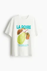 Remera blanca de algodón con cuello redondo y mangas cortas. Estampado frontal con una pera, el texto 'LA POIRE' y texto en francés.