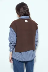 Chaleco tejido sin mangas de color negro, con cuello redondo y diseño de textura sutil. Presenta un corte recto con terminaciones acanaladas en el ruedo y hombros levemente estructurados.