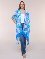Kimono de gasa azul con estampado botánico de hojas tropicales en tonos celestes, verdes y rosados. Presenta un diseño abierto al frente con mangas cortas y amplias, ruedo asimétrico estilo pañuelo y detalle de borlas en las esquinas inferiores.