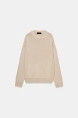 Jersey de punto grueso color beige, con cuello redondo y manga larga, de diseño amplio y acabados en rib.