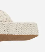 Sandalia tipo flatform con suela de plataforma plana y tira ancha superior, ambas con textura trenzada. Diseño sin cierre con puntera redonda.