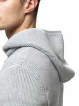 Campera tejida con capucha, confeccionada en poliéster, con cierre frontal completo y diseño de punto acanalado.