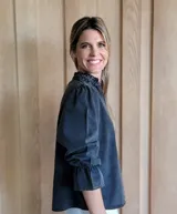 Blusa de algodón con cuello mao y volados, mangas largas con puños elásticos y corte holgado.