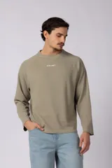 Buzo de cuello redondo con textura tipo waffle, color verde oliva claro. Presenta mangas raglán y un pequeño estampado minimalista en el centro del pecho con el texto VCP CNPT.