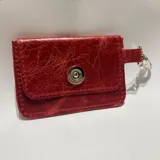 Tarjetero pequeño de cuero rojo con cierre metálico plateado y llavero.