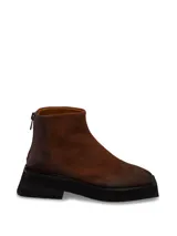 Bota corta marrón de gamuza con suela track negra y cierre trasero.